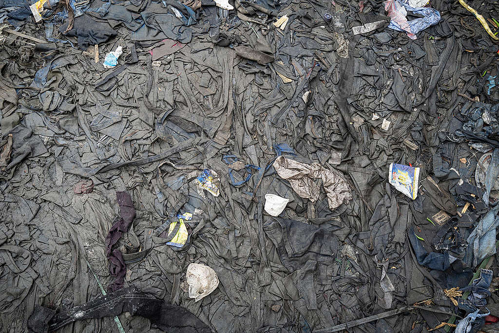 Fast Fashion Research in Kenya. Gikoba market in Nairobi: the ground is covered with layers of textile waste. © Kevin McElvaney / Greenpeace