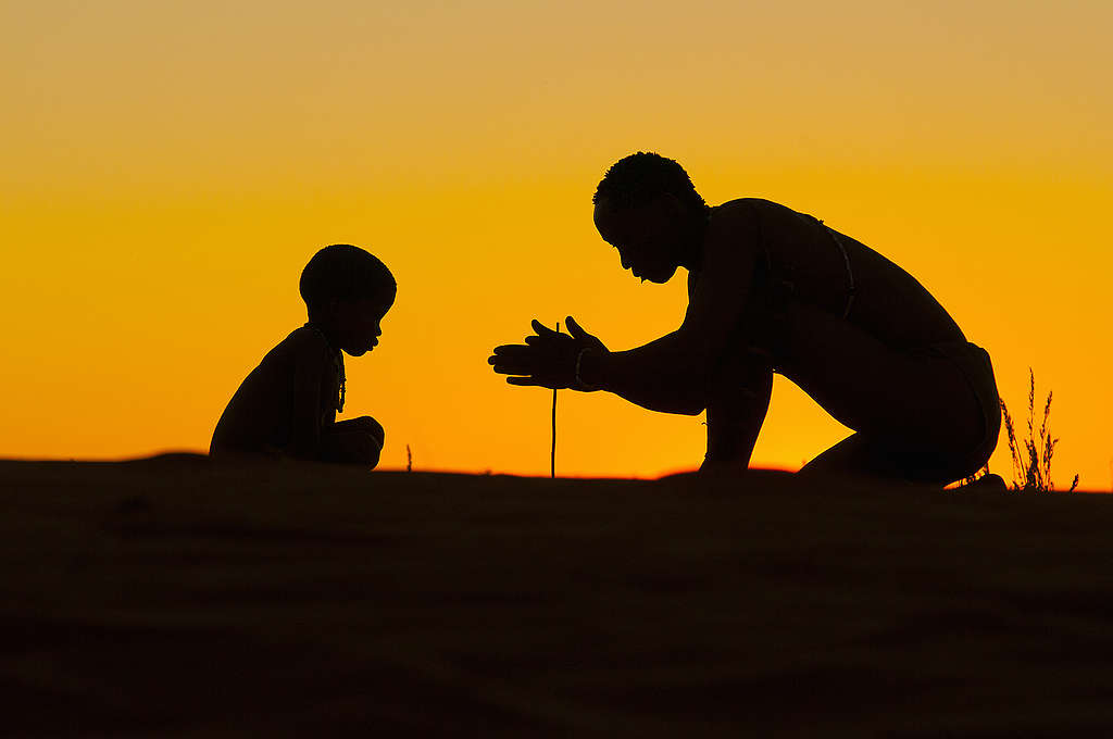 Silhouette of San on top of dunes at sunset. Stampriet District, Namibia