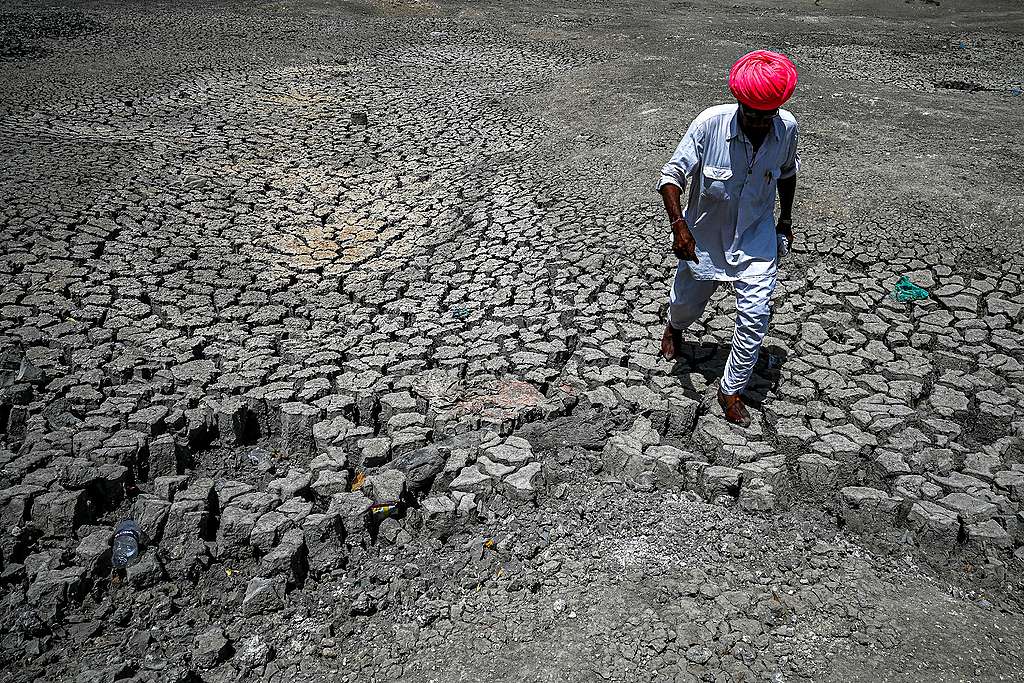 May 11, 2022. Shivaram, a villager walking through the cracked bottom of a dried-out pond on a hot summer day at Bandai village in Pali district. - Every day dozens of villagers, mostly women and children, wait with blue plastic jerry cans and metal pots for a special train bringing precious water to people suffering a heatwave in India's desert state of Rajasthan. ©PRAKASH SINGH/AFP via Getty Images.