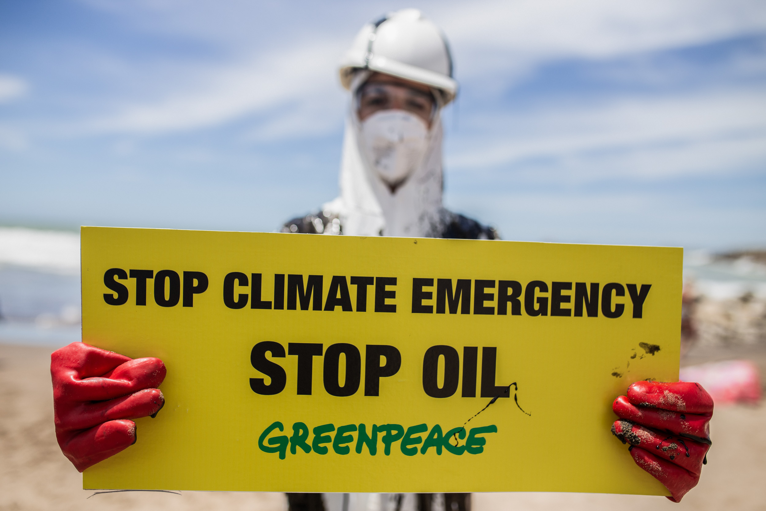 Activist with sign Stop climate emergency, stop oil