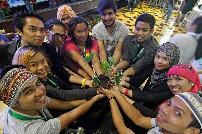 Young leaders from across the Philippines join hands in the centre of a circle holding seedlings to symbolise their call for electoral candidates to prioritise safe, healthy and sustainable food and agriculture systems. 