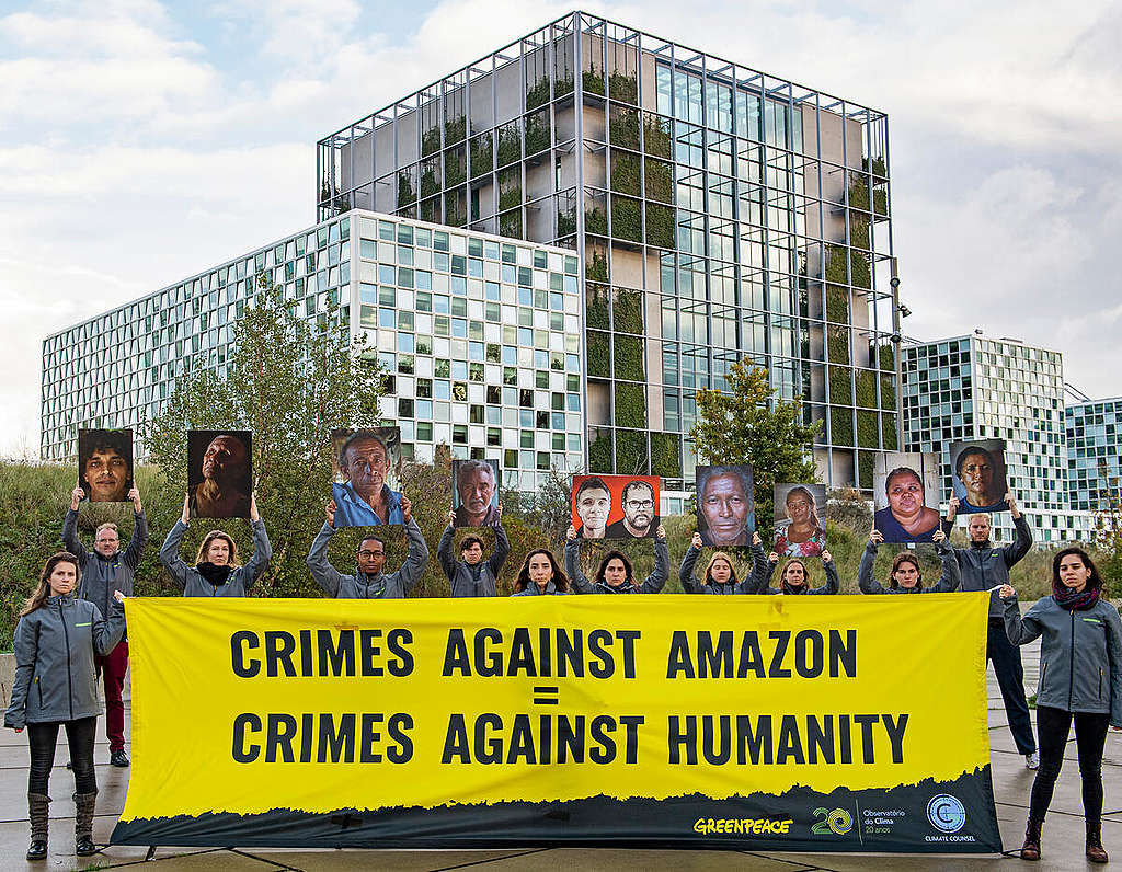 Activists demonstrate in front of the International Criminal Court © Marten  van Dijl / Greenpeace