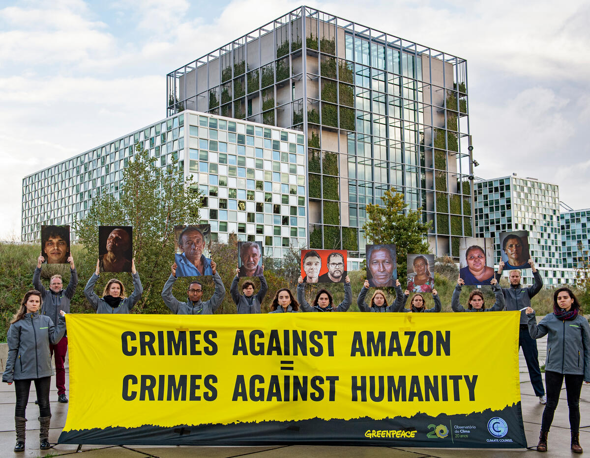 Activists demonstrate in front of the International Criminal Court © Marten  van Dijl / Greenpeace