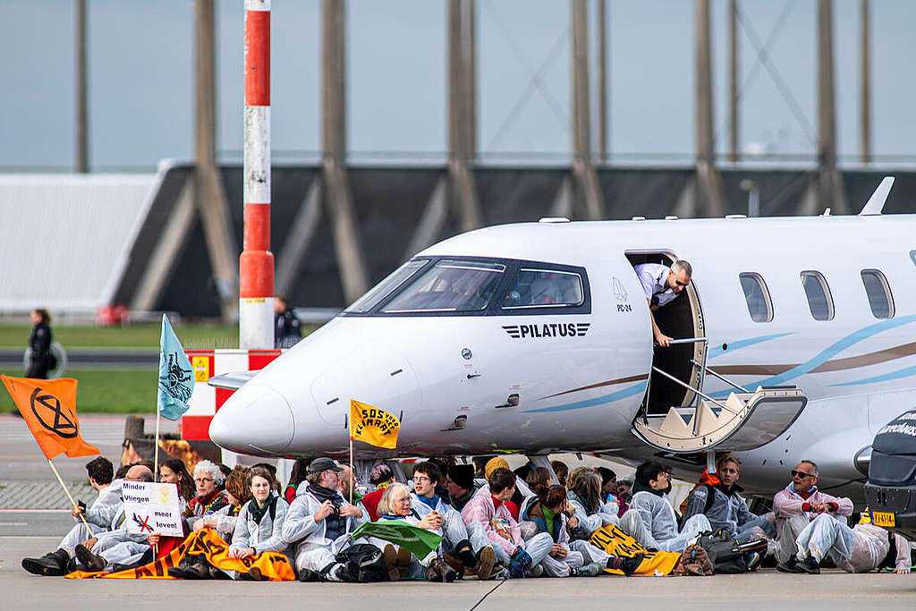 Schiphol Airport Protest in Amsterdam. A large group of activists from Extinction Rebellion and Greenpeace Netherlands hold a peaceful protest at Amsterdam Schiphol Airport, the second biggest in the EU, stopping private jets from landing and taking off and sitting and cycling around the area where private jets are parked. © Marten van Dijl / Greenpeace