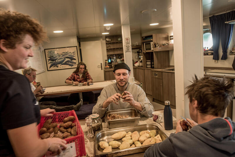 Musician Ali John Meredith-Lacey (also known as Novo Amor) peels potatoes with other crew members in the mess onboard the Arctic Sunrise, in the Erebus and Terror Gulf, Antarctica. © Tomás Munita / Greenpeace