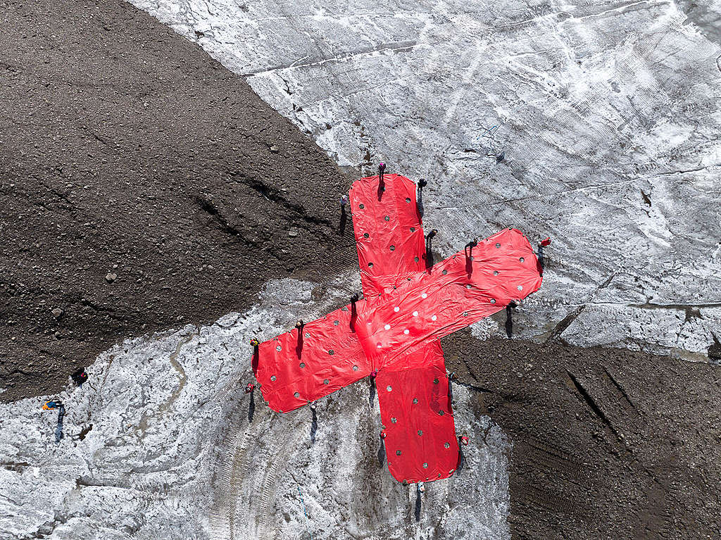 A group of senior Swiss women lay giant band-aids on newly exposed earth between the melting Scex Rouge and Tsanfleuron Glaciers, to protest the Swiss government’s inaction on the growing climate emergency and its impacts on health. © Matthias Lüscher / Greenpeace