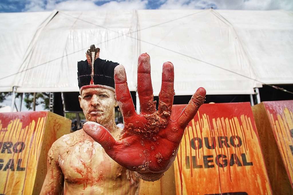 Image of an Indigenous man protesting against illegal mining in the Amazon, Brazil © Tuane Fernandes / Greenpeace 