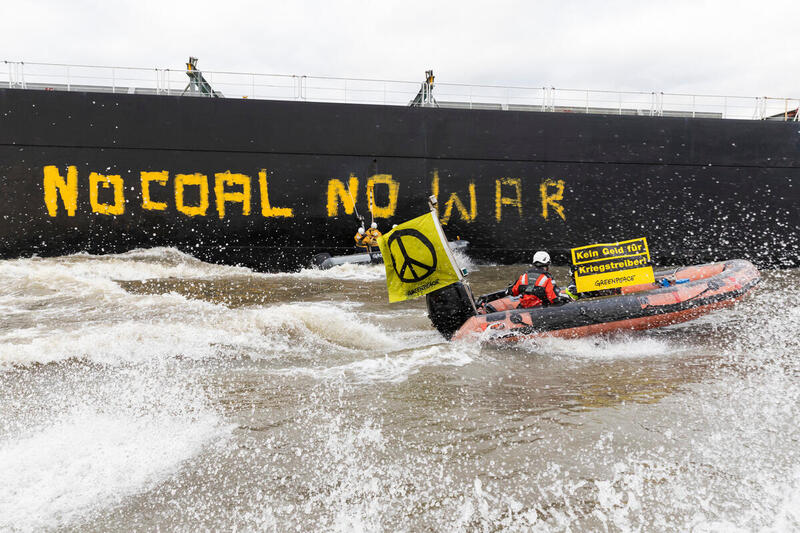 Activists from Greenpeace protest against Russian coal imports with inflatable boats in the Port of Hamburg, painting "No Coal No War" in two-meter letters on the side of the freighter "Grant T," which is loaded with a good 100,000 tons of Russian coal.