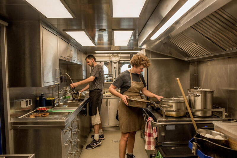 Cook Elena Müller (r) and her assistant Graham Gilby in the Galley onboard the Arctic Sunrise in Antarctica. © Tomás Munita / Greenpeace