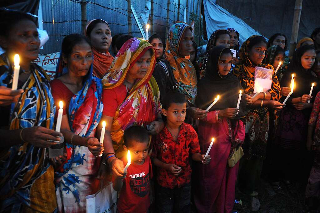 Garment workers and relatives of victims hold a memorial at the site of the Rana Plaza garment factory building collapse.
