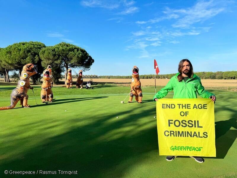 Activists dressed as dinosaurs with fossil fuel companies’ logos entered a golf course where OMC delegates were playing, mocking their reckless unsustainable behaviour and participating in the game while another activist displays a banner reading “End the age of fossil criminals”.