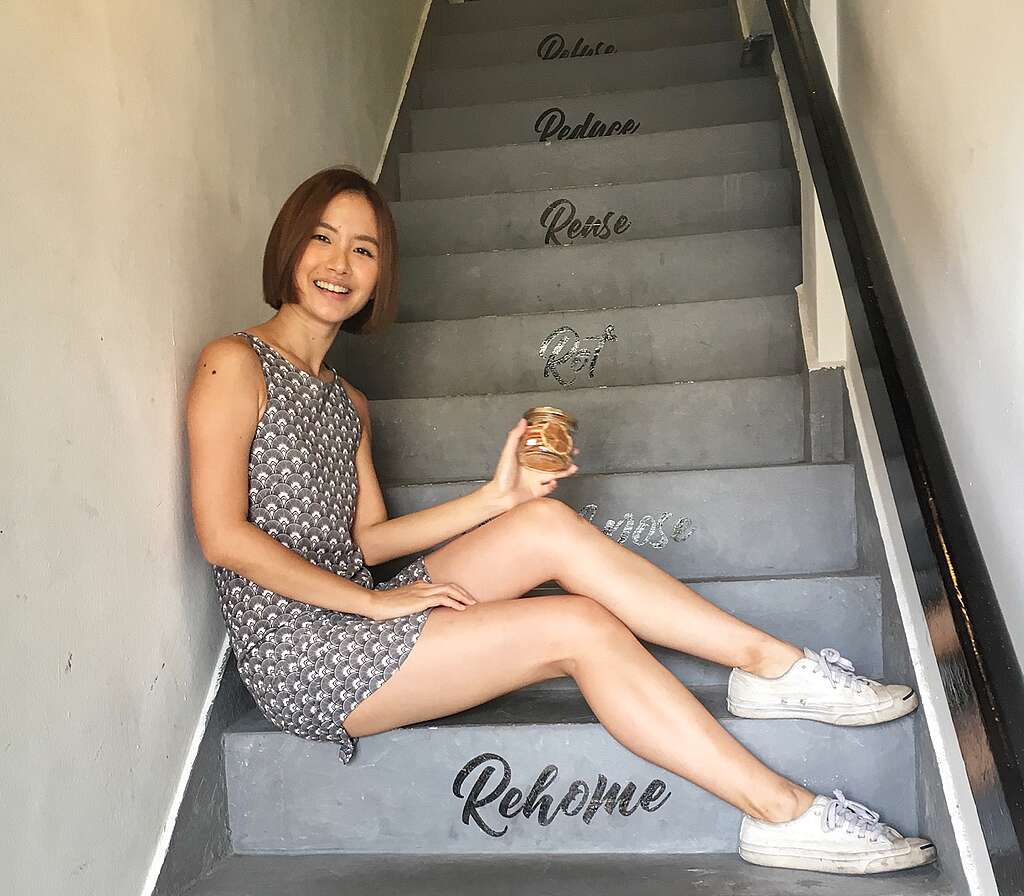 A woman sitting on a staircase of a store called "Rehome"