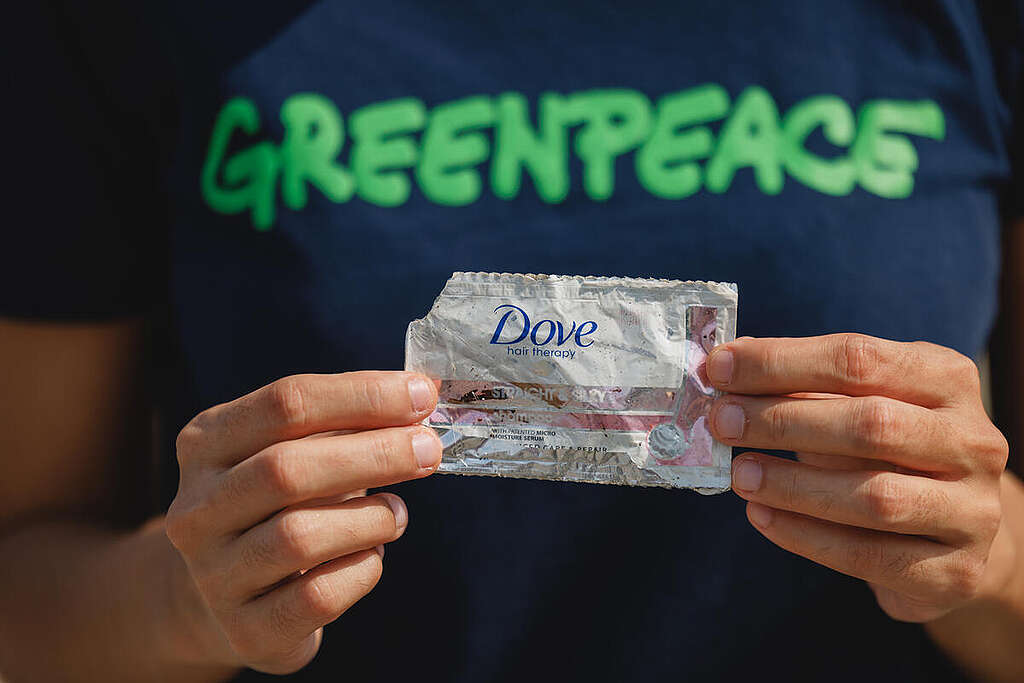 Marian Ledesma from Greenpeace Philippines picks up a piece of plastic trash from the company Dove around Freedom Island at Las Pinas, Philippines. This wetland part of Manila bay called Las Piñas - Parañaque Critical Habitat and Ecotourism Area (LPPCHEA) is a 175 hectare protected area. It is always filled with plastic trash that comes from the ocean. The amount of plastic trash here does not stop even with the continuous shore clean up by various groups.