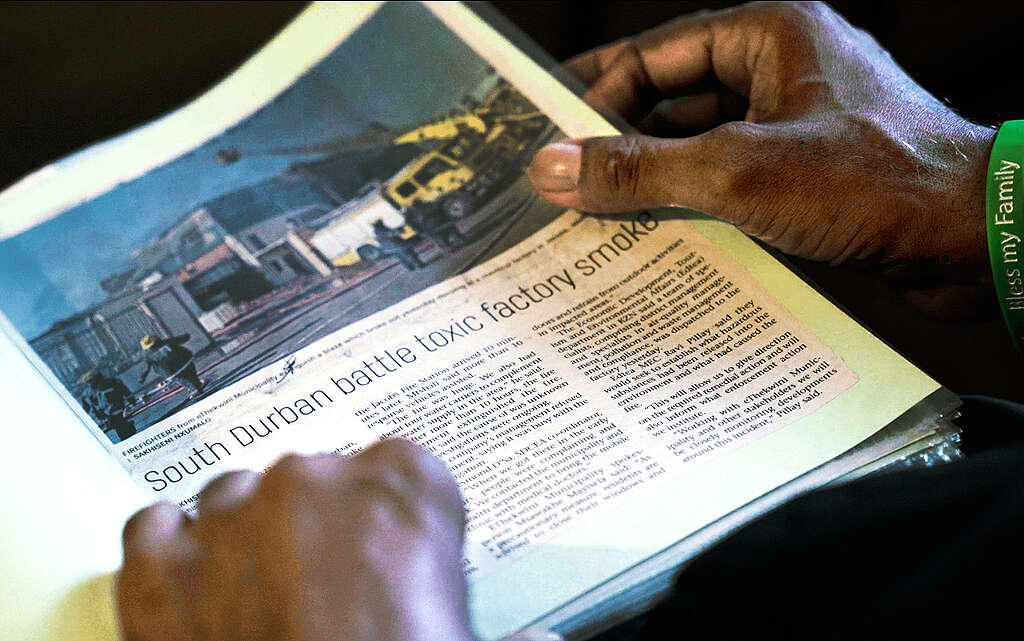 Video still from CRUDE documentary showing a newspaper headline that reads: South Durban battle toxic factory smoke
