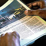 Video still from CRUDE documentary showing a newspaper headline that reads: South Durban battle toxic factory smoke