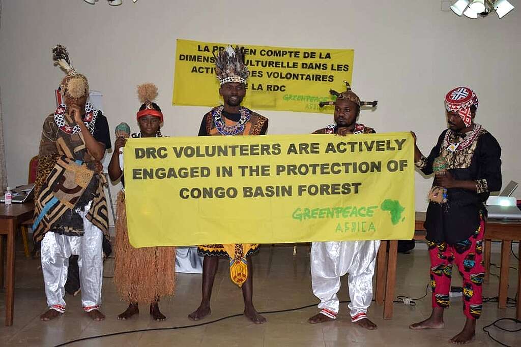 Activists holding a banner with the words DRC volunteers are actively engaged in the protection of Congo Basin forest.