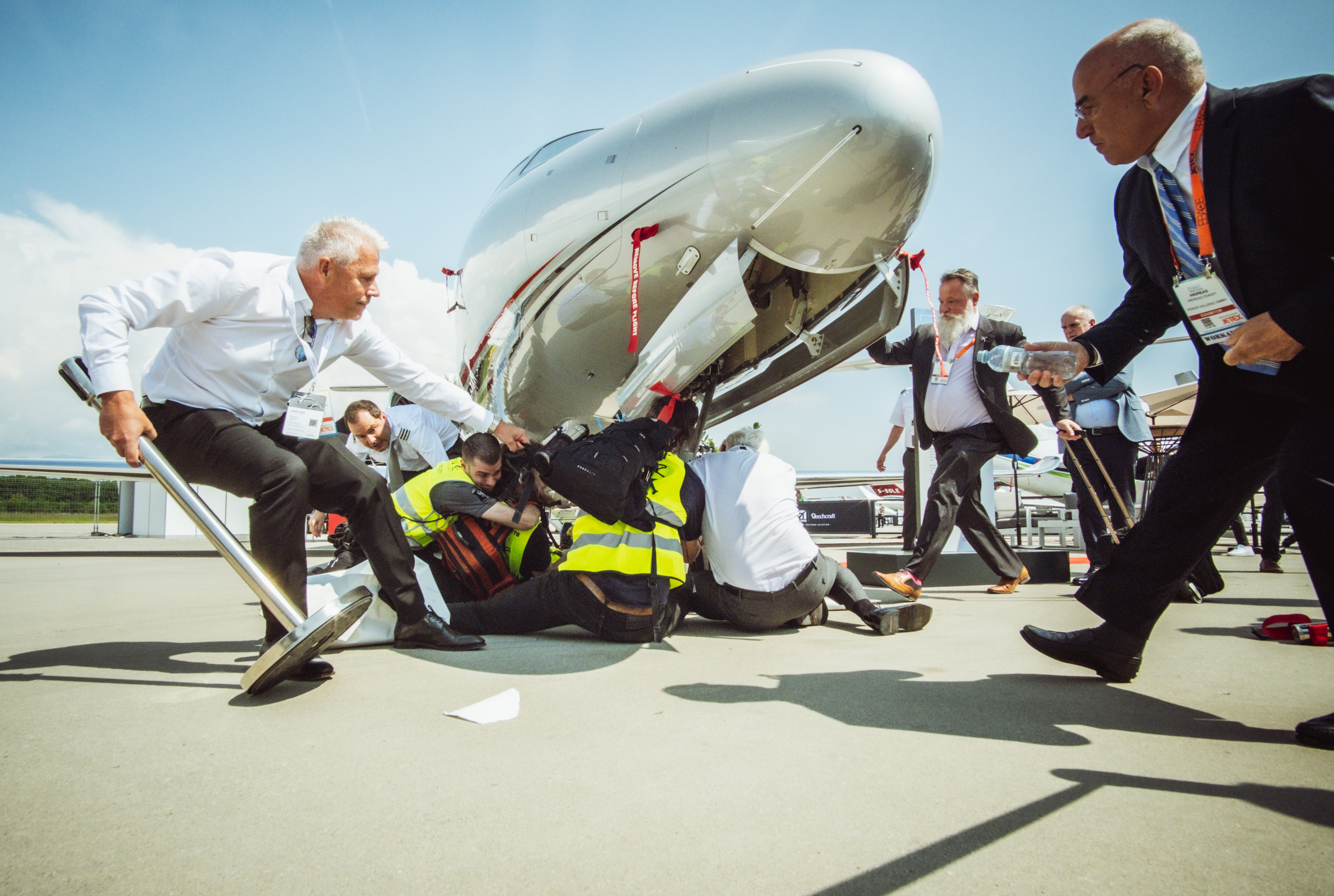 A hundred climate activists supporting Greenpeace, Stay Grounded, Extinction Rebellion, Scientist Rebellion and other climate movement groups from 17 countries have disrupted Europe’s biggest private jets sales fair, the annual European Business Aviation Convention & Exhibition (EBACE) in Geneva, demanding a ban on private jets.  Activists were peacefully occupying private jets that are exhibited at the business event by Geneva airport, having chained themselves to aircraft gangways and the exhibition entrance in order to keep prospective buyers from entering. The protestors stuck giant tobacco-style health warning labels on the airplanes marking them as toxic objects and warning that ‘private jets burn our future’, ‘kill our planet’, and ‘fuel inequality’. Public service announcements from loudspeakers carried by the activists exposed the dramatic consequences of private jets for our planet and revealed the hypocrisy of promoting private jets amidst rising social inequality. © Thomas Wolf / Stay Grounded