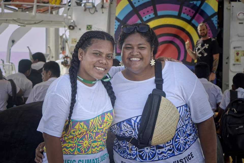 Two young women volunteering at the Pacific Climate Justice ship tour smiling at the camera