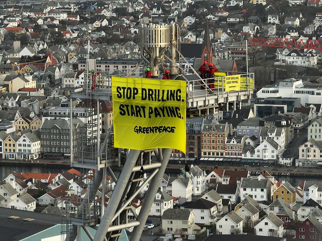 In a final stand, protestors climbed the platform's 125m flare boom, and waved a banner saying 'Stop drilling. Start Paying.' Meanwhile five fellow activists led by Greenpeace Southeast Asia executive director, Yeb Saño, on board Greenpeace Nordic's 8-meter Tanker Tracker boat sailed out to intercept the 51-000-tonne White Marlin vessel contracted by Shell as it approached the port. © Matthew Kemp / Greenpeace