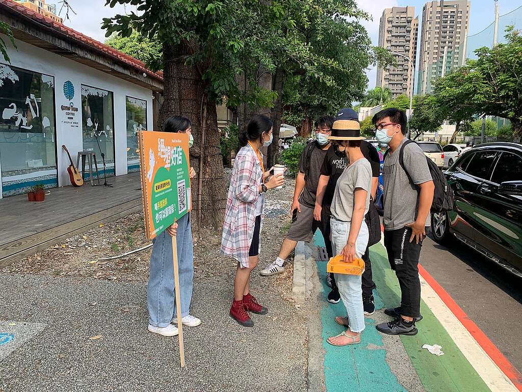 two greenpeace volunteers explaining the importance of reusable cup to 4 regular citizens