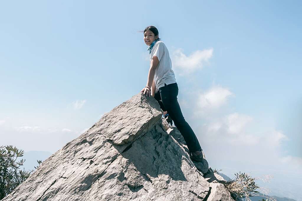 a young woman on top of a rock