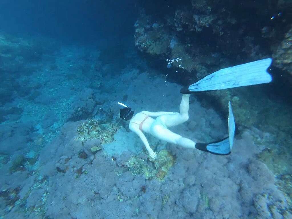 A woman is snorkling under the ocean