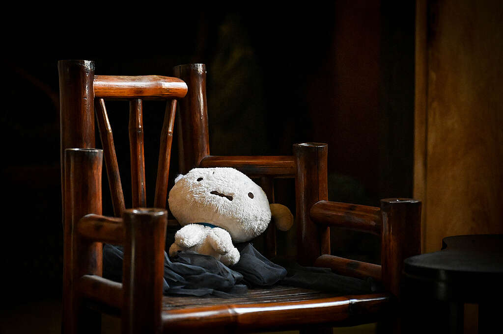 A stuffed toy sits on a bamboo chair