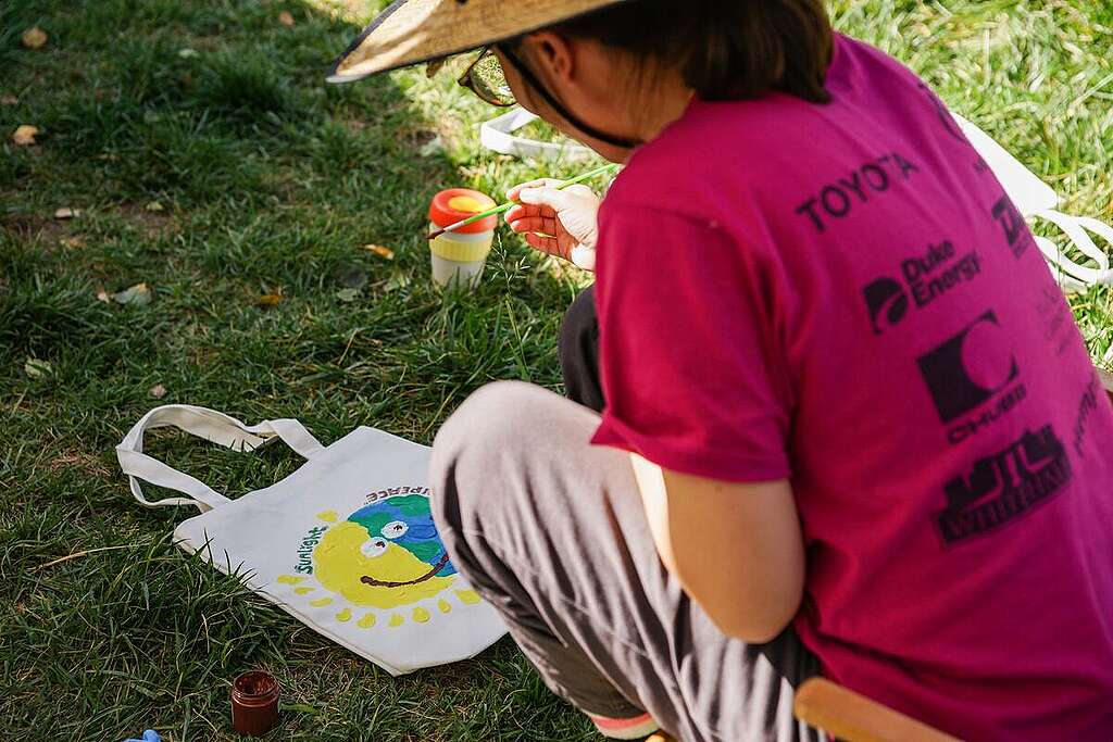 A person hand paints a sun and earth image on a canvas bag in Beijing. © Greenpeace / Yan Tu A person hand paints a sun and earth image on a canvas bag in Beijing. © Greenpeace / Yan Tu