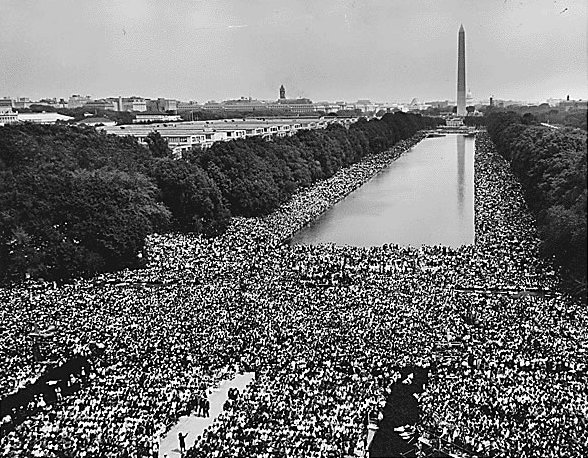 View of the crowd at 1963 Civil Rights March on Washington, D.C. A wide-angle view of marchers along the mall, showing the Reflecting Pool and the Washington Monument. 28 August 1963, US National Archives at College Park