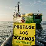 A Greenpeace crew member holds a banner reading 'Protege Los Océanos' (Protect The Oceans) from a RHIB in the Pacific Ocean. The Greenpeace ship Arctic Sunrise is seen in the background with a banner that reads: 'Los Oceanos Son Vida' (Oceans Are Life).

The Arctic Sunrise is on a six-week expedition around the Galápagos islands, with scientists from the Jocotoco Conservation Foundation, the Charles Darwin Foundation, the Galápagos Science Center, MigraMar and Galápagos park rangers. The expedition will showcase the power of marine protection by documenting the success of the Galápagos Marine Reserve through the incredible wildlife and habitats of the sea near the Galápagos. Data collected during the expedition will help to make the case for a new high seas protected area.