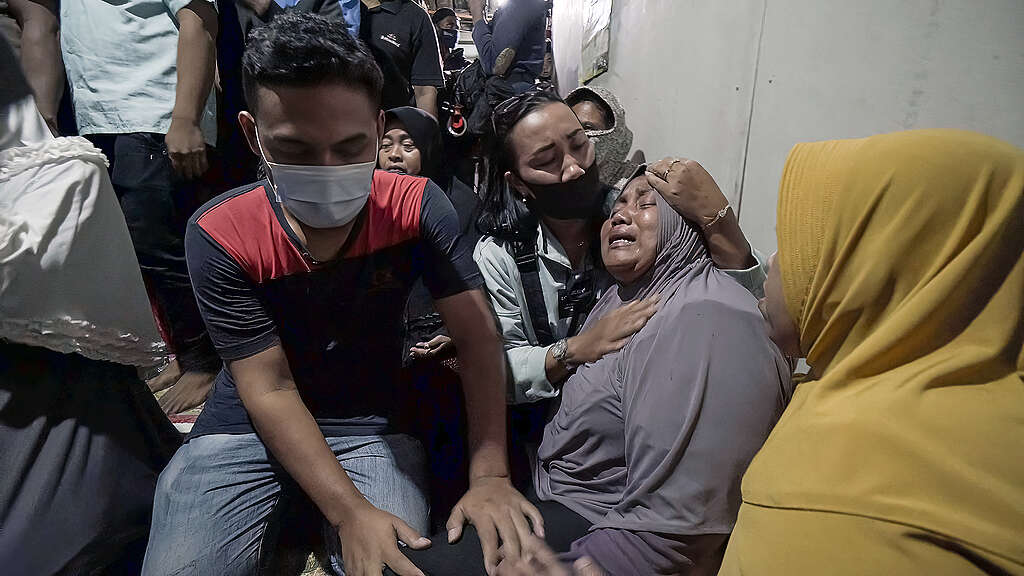 Mother of Wendi, a migrant fisher, cries at the sight of her son's coffin. A still from documentary film, "Before You Eat", produced by the Indonesian Migrant Workers Union (SBMI) and supported by Greenpeace Indonesia. Mother of Wendi, a migrant fisher, cries at the sight of her son's coffin. A still from documentary film, "Before You Eat", produced by the Indonesian Migrant Workers Union (SBMI) and supported by Greenpeace Indonesia.