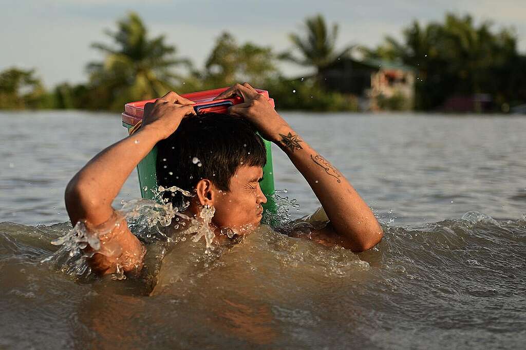 A man wades through a flooded street in Milaor in Naga City in Philippines. Several towns are still submerged in water brought by Severe Tropical storm Kristine (international name: Trami) in Camarines Sur. © Noel Celis / Greenpeace A man wades through a flooded street in Milaor in Naga City in Philippines. Several towns are still submerged in water brought by Severe Tropical storm Kristine (international name: Trami) in Camarines Sur. © Noel Celis / Greenpeace