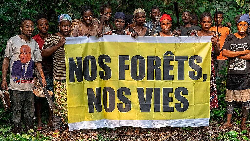 People holding a banner in French that reads: People holding a banner in French that reads: