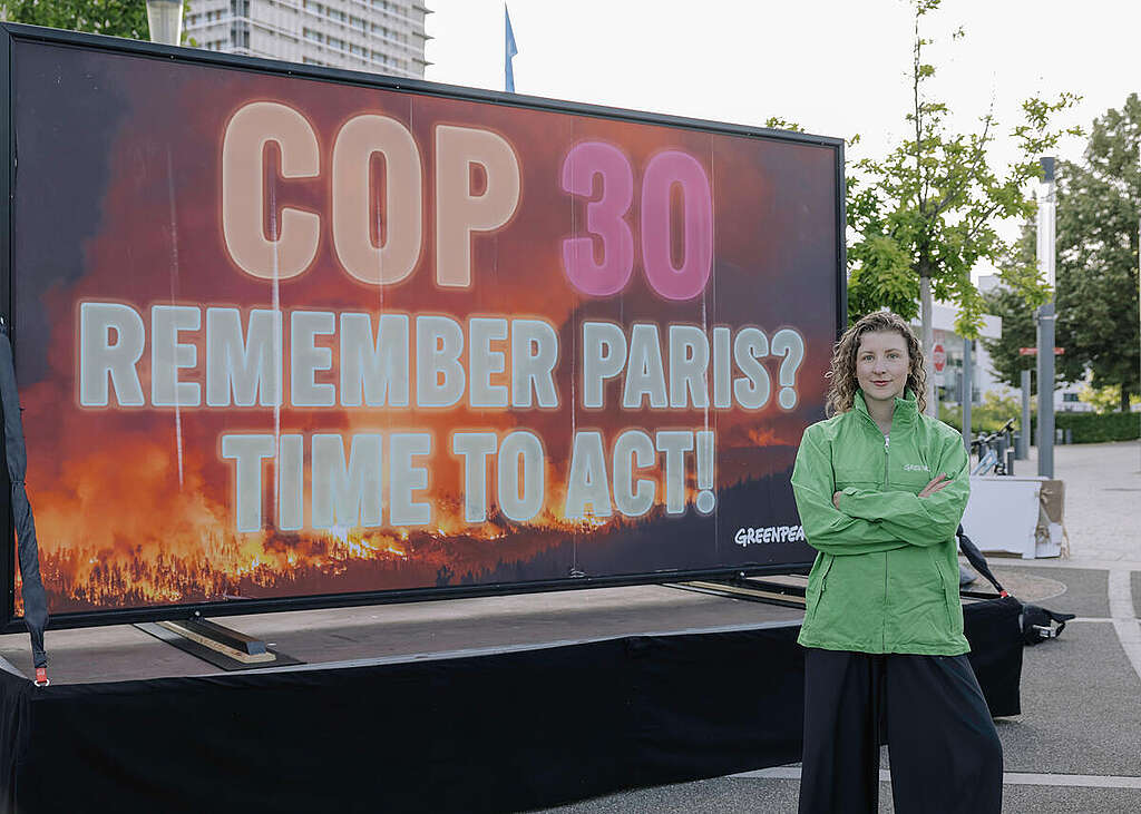 Sarah Zitterbarth in front of Greenpeace Billboard in Bonn. © Marie Jacquemin / Greenpeace