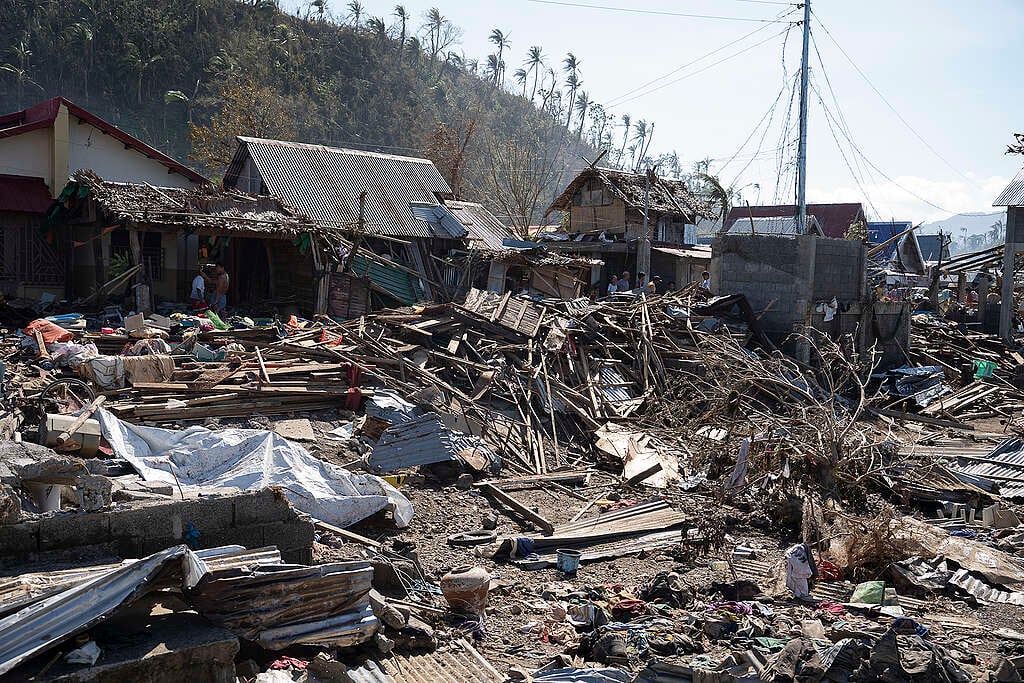 Destroyed houses and debris are scattered across a coastal neighborhood in the Philippines