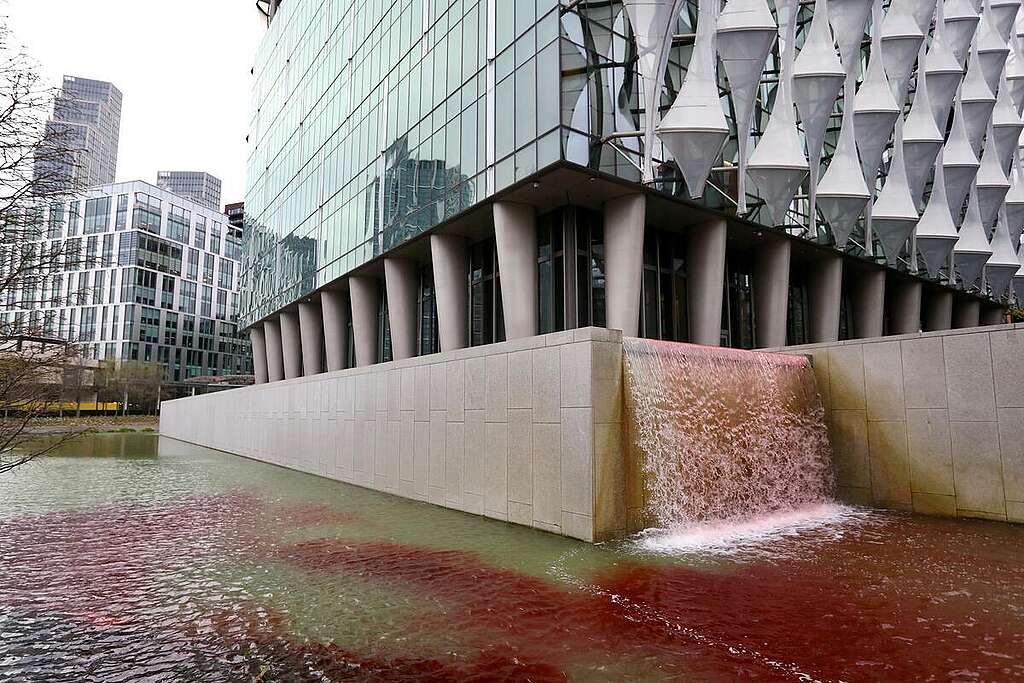 Greenpeace UK activists pour 300 litres of blood-red dye into the US Embassy pond in London, to highlight the death and devastation caused in Gaza as a direct result of the US’ continued sale of weapons, ammunition and military hardware to Israel. Twelve activists tipped the non-toxic, biodegradable dye from containers emblazoned with the words ‘Stop Arming Israel’ into the large pond located in front of the embassy building in Nine Elms, south-west London. © Greenpeace