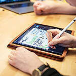 Graphic Recorder Maren Collet drawing with an iPad for the education team in Hamburg.  Maren draws the protocol of a video call with a school that participated in the Greenpeace Climate Lab. Markus Power from the Schools for Earth team takes part in the call.