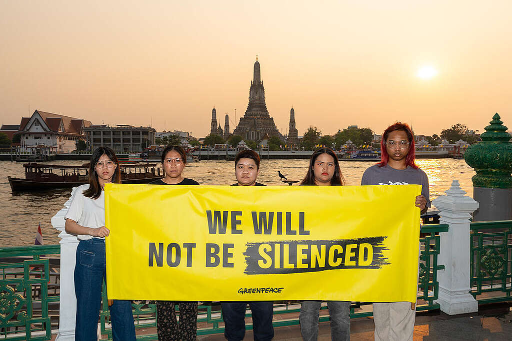 A group of Greenpeace Thailand activists gathered at an iconic place in Bangkok, Thailand, to show solidarity with the global movement for climate justice. Holding banners reading "We will not be silenced" and "Stop Big Oil Bullies", the group called for an end to the intimidation tactics used by fossil fuel companies like Energy Transfer attempting to intimidate climate activists, journalists, and anyone who dares speak truth to power. © Chutiphon Phisitthanadun / Greenpeace