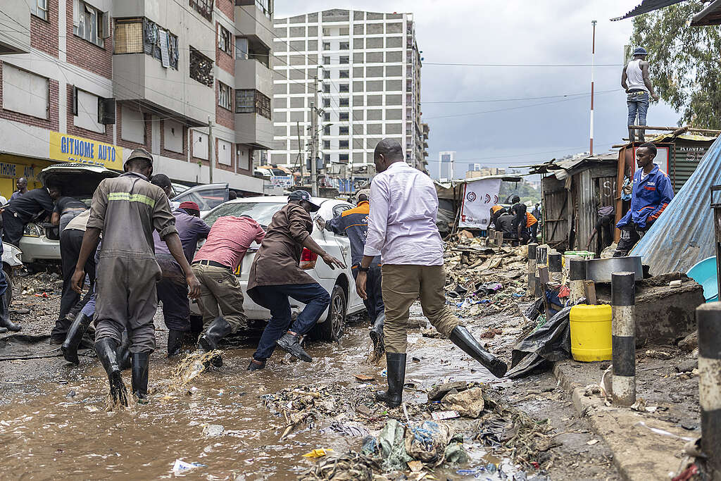 People salvage damaged vehicles from receding flood waters in downtown Nairobi following a night of heavy rainfall that resulting in heavy flooding around Nairobi on March 07, 2026.