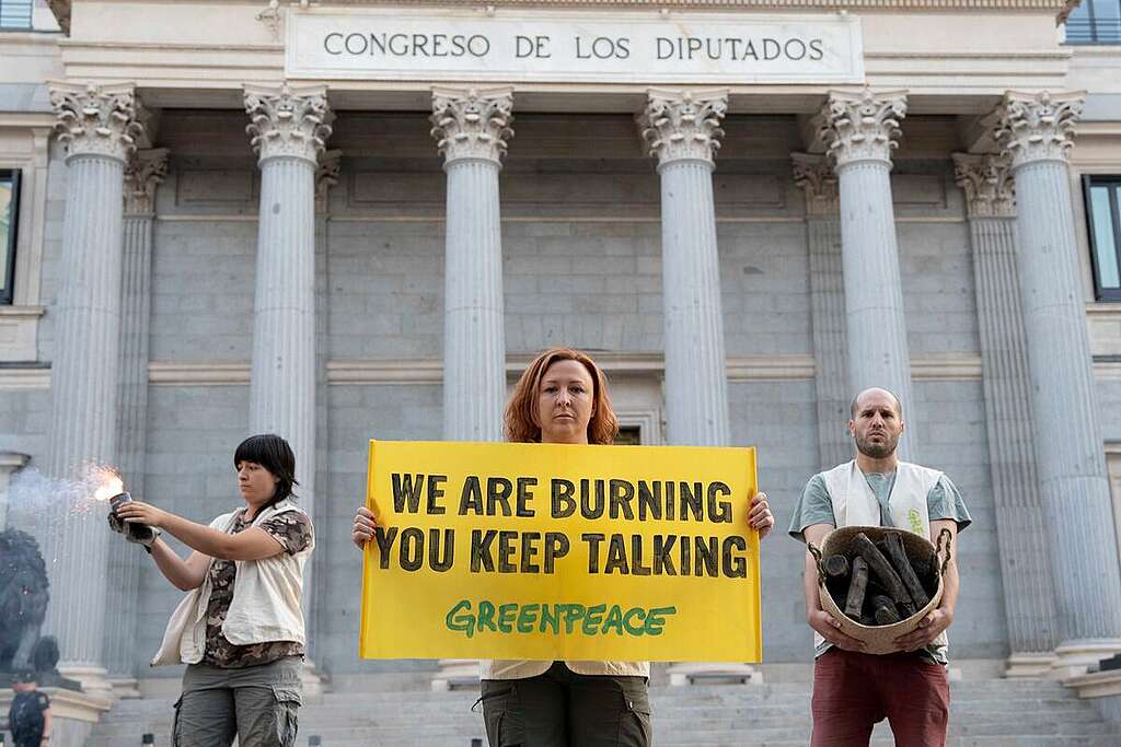 Artificial smoke, ashes, burnt logs and a black banner outside the Congress of Deputies reading “Spain is burning. Your inaction is killing us”. This is how Greenpeace Spain activists peacefully protested this morning in Madrid to show their solidarity with the thousands of people affected by the fires, as well as demanding that political groups and administrations act and engage in real politics to address the climate emergency. All this at the start of a fourth heatwave and with much of the country affected by historic fires that have already claimed 15 direct fatalities and displaced more than 100,000 people.