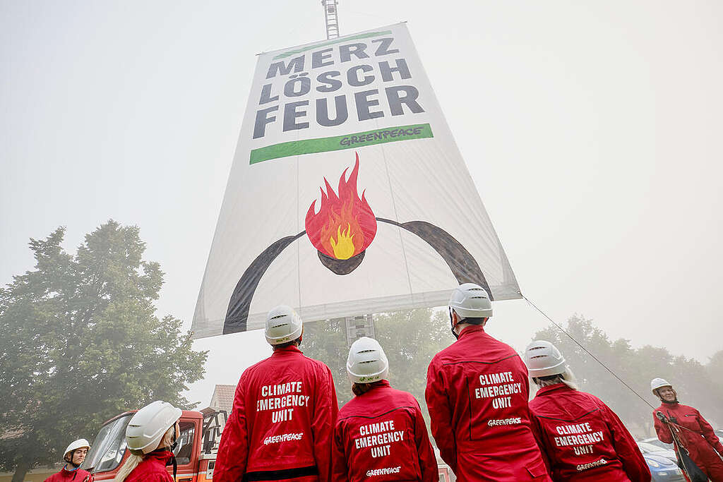 Greenpeace activists demonstrate in front of Neuhardenberg Castle for better climate protection, using a fire truck and a banner reading “Merz, put out the fire.”

There, the governing coalition is primarily discussing economic issues. While heat protection and climate adaptation are on the agenda, the Union continues to categorically reject the SPD’s demand to enshrine a “joint mission for climate adaptation and nature conservation” in the Basic Law.