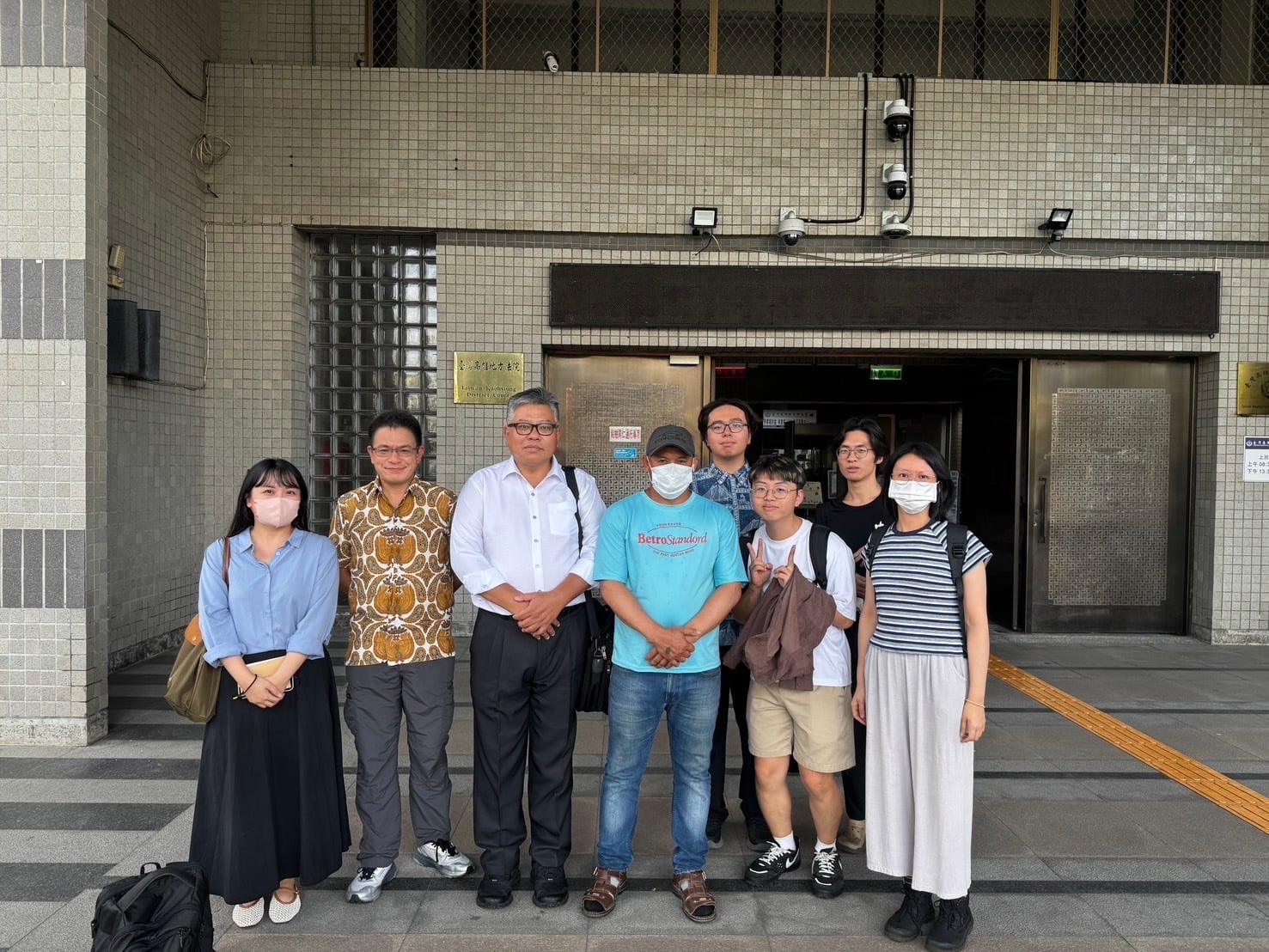Several people are standing in front of a building