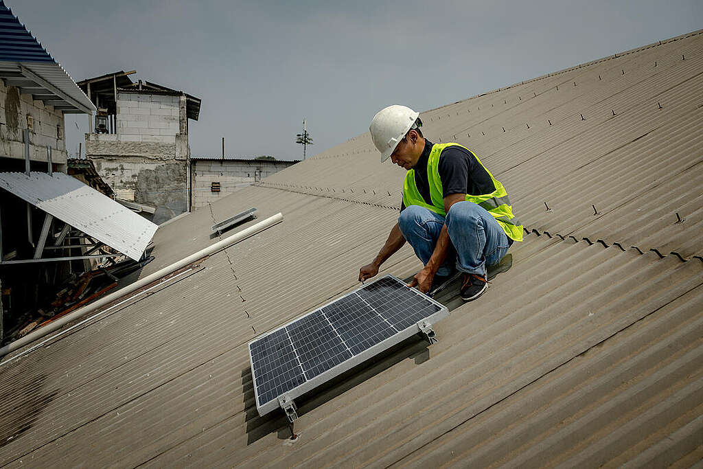 Rooftop solar panel installation in Kampung Muka Jakarta, Indonesia. Rooftop solar panels are being installed in the Kampung Muka area of North Jakarta through a collaboration between Greenpeace Indonesia, Jaringan Rakyat Miskin Kota (JRMK) and Urban Poor Consortium (UPC)). This community-scale rooftop solar installation is part of efforts to accelerate the energy transition in Indonesia to renewable energy and expand clean power access in urban neighborhoods