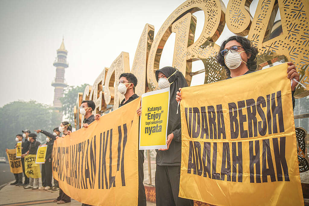 Members of Greenpeace Indonesia Forest Fires Prevent Team (Tim Cegah Api) hold posters and banners during a protest over wildfire haze affecting Palembang, South Sumatra, Indonesia, October 7, 2026. Haze has covered the city for nearly two months, with air pollution reaching hazardous levels. The haze has also affected air quality in Singapore and Malaysia.