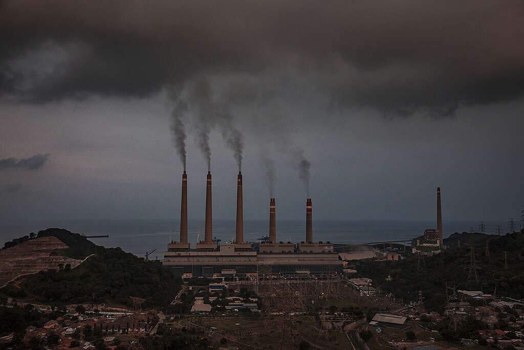 עשן אפור יוצא מחמש ארובות של מפעל.
