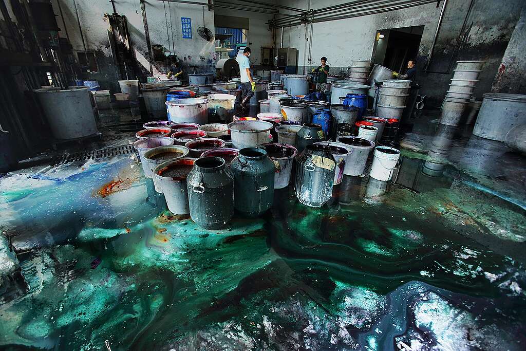 דליים מלאים בצבעים שונים שנשפכים על הרצפה במפעל צביעת בדים בסין