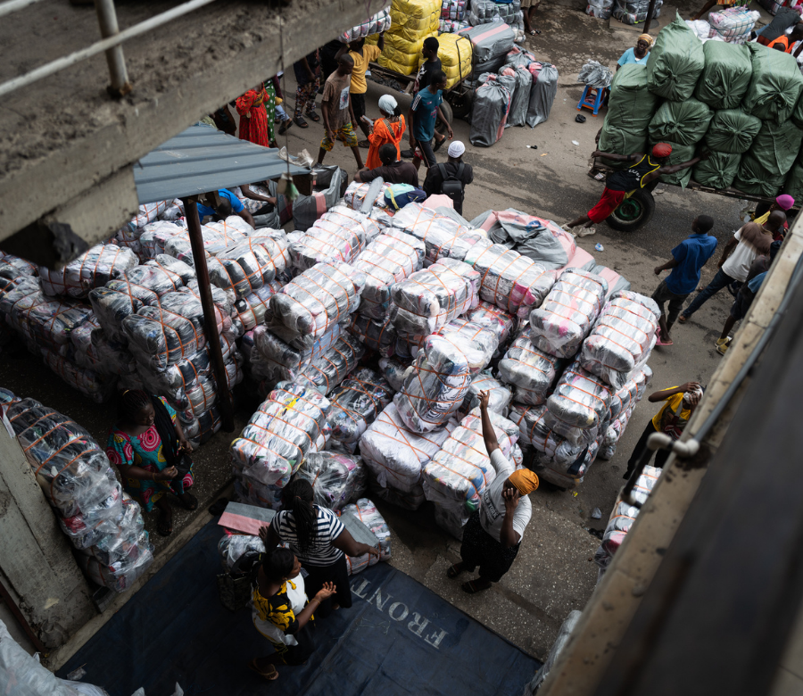 חבילות ארוזות של בגדים משומשים בצילום מהאוויר של שוק בגדים באקרה, גאנה. 