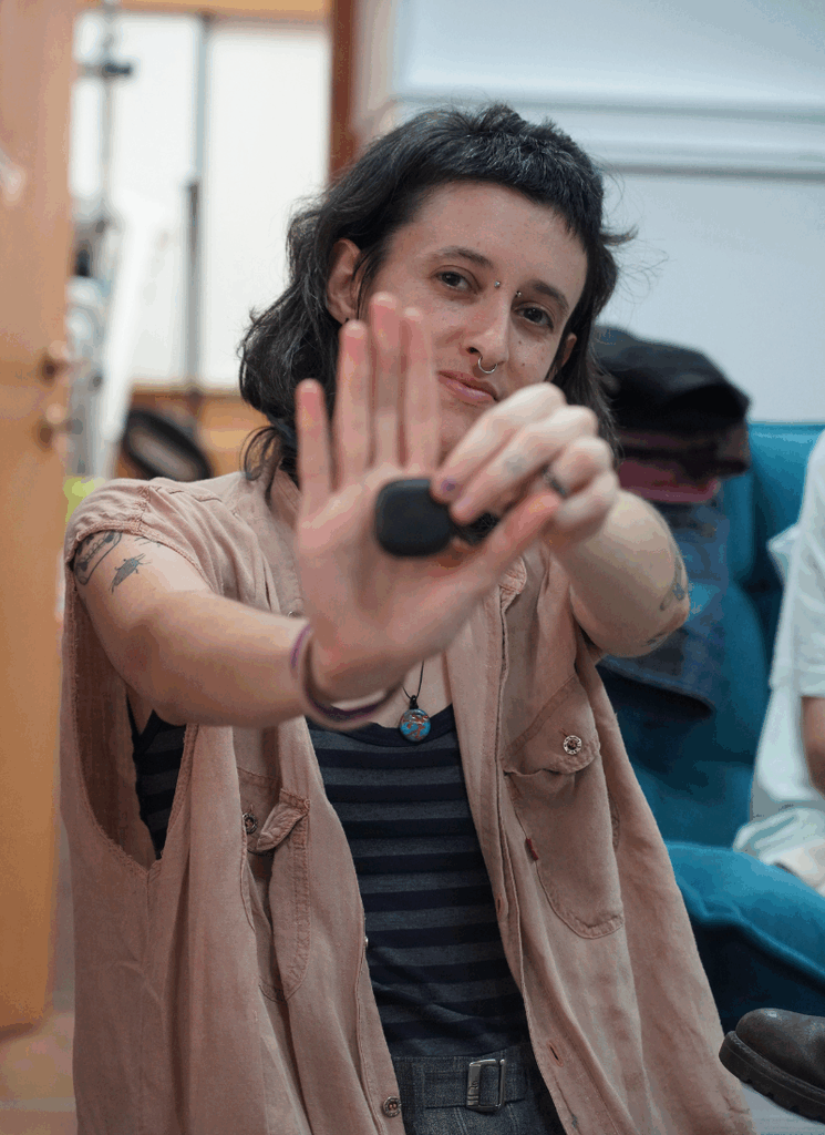 פעילת גרינפיס ישראל מחזיקה אייר-טאג (מכשיר ג׳י.פי.אס).