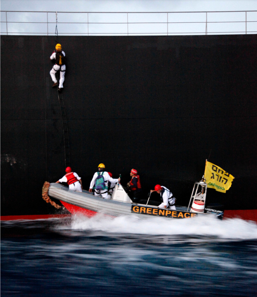 פעילי גרינפיס בסירה מתנפחת, מטפסים על ספינה שמביאה משלוח נפט לישראל.