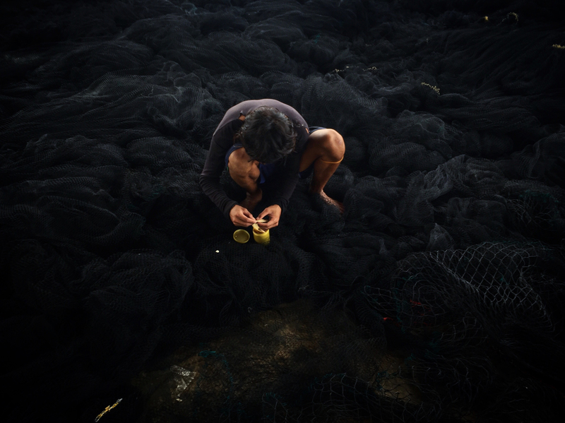 A fisherman repairs a Thai purse seine in Ranong, southern Thailand.